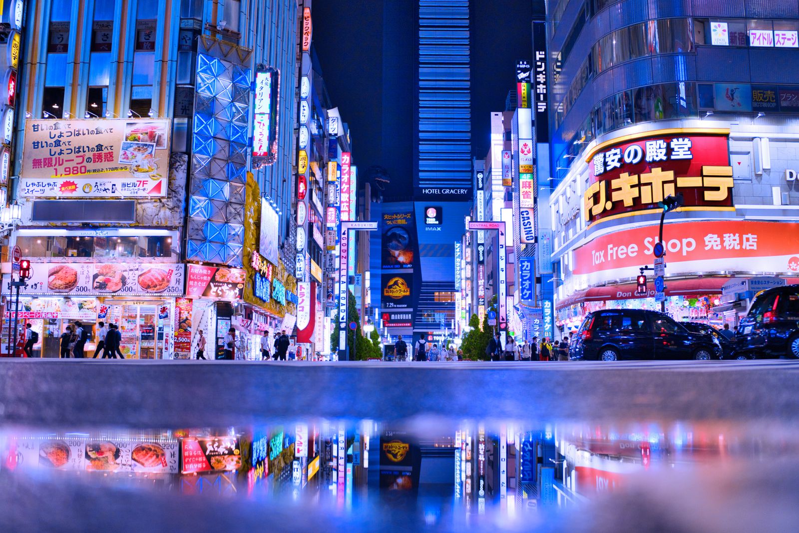 Neon signs and crowds in Shinjuku at night.