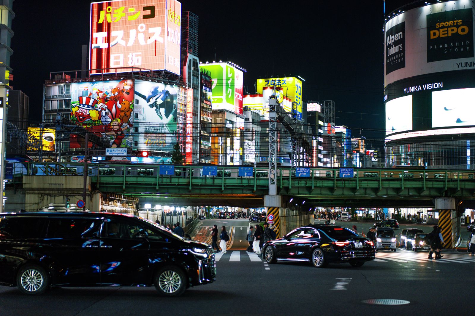 Shinjuku, Tokyo at night, lit by neon signs.